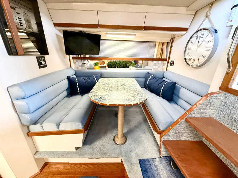Slide: The Image of 1988 Carver Montego 3257 interior with blue seating, dining table, TV, and wall clock. - 41