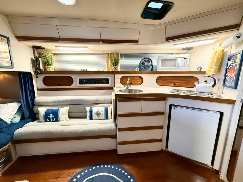 Slide: The Image of 1988 Carver Montego 3257 interior with cozy seating, kitchenette, and nautical decor. - 43