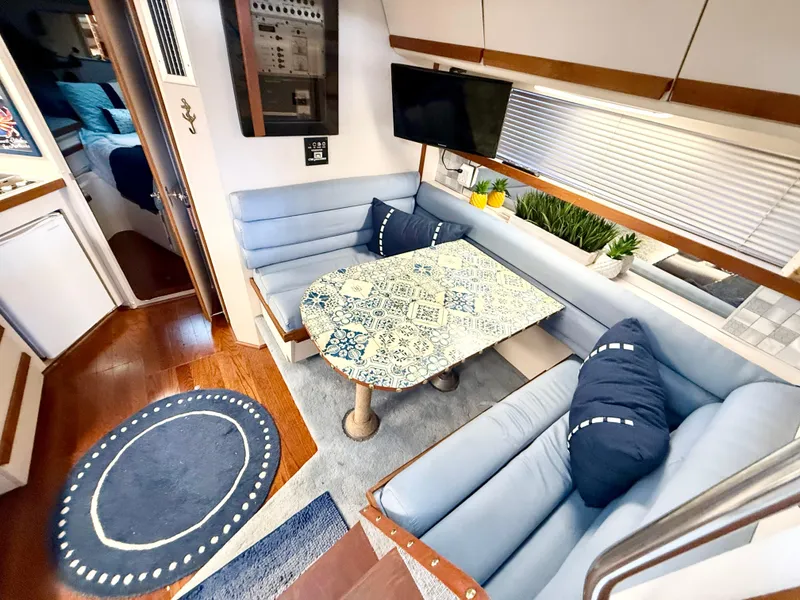 Slide: The Image of 1988 Carver Montego 3257 interior with blue seating, patterned table, and wall-mounted TV. - 45