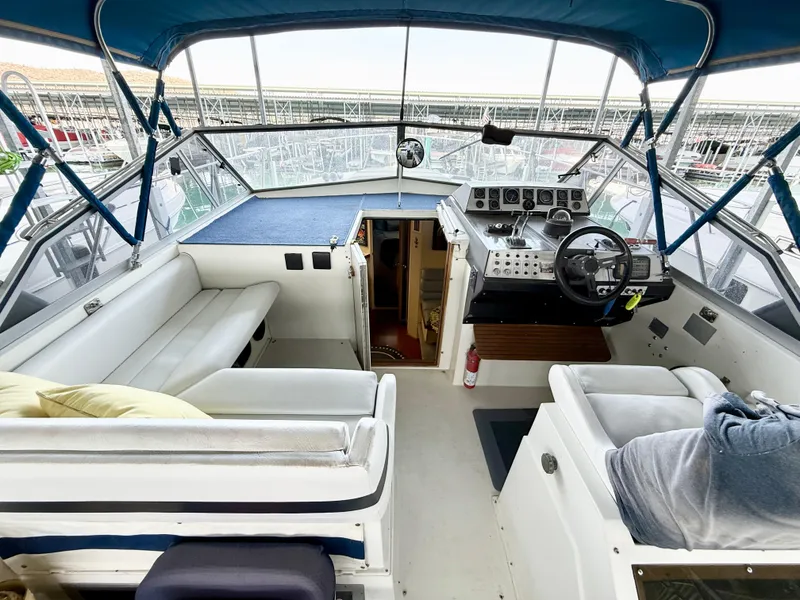 Slide: The Image of 1988 Carver Montego 3257 boat interior with helm, seating, and blue canopy. - 48