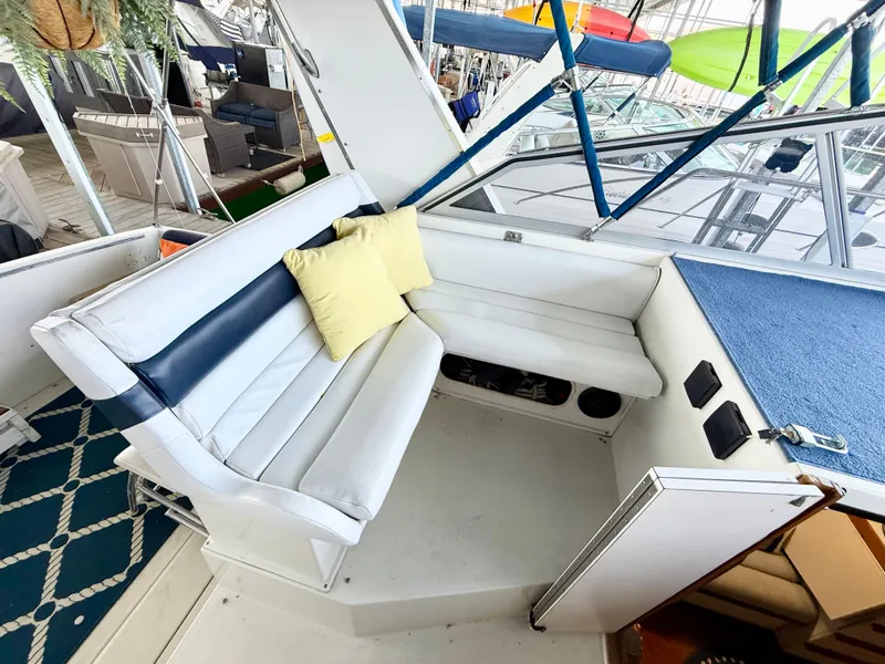 Slide: The Image of Interior of 1988 Carver Montego 3257 boat with white seating and yellow cushion. - 49