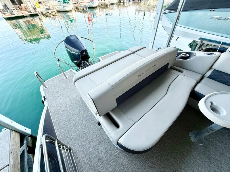 Slide: The Image of 2019 Bennington SX 25 Premium Swingback boat with comfortable seating, docked by clear water. - 10
