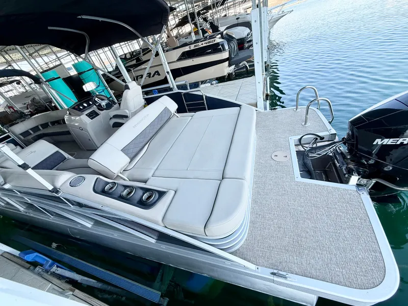 Slide: The Image of 2019 Bennington SX 25 Premium Swingback pontoon boat with spacious seating and outboard motor. - 3