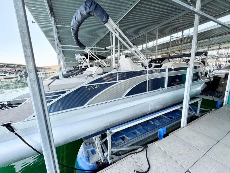 Slide: The Image of 2019 Bennington SX 25 Premium Swingback pontoon boat docked under a covered marina. - 4