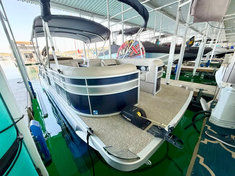 Slide: The Image of 2019 Bennington SX 25 Premium Swingback pontoon boat docked under a covered marina. - 6