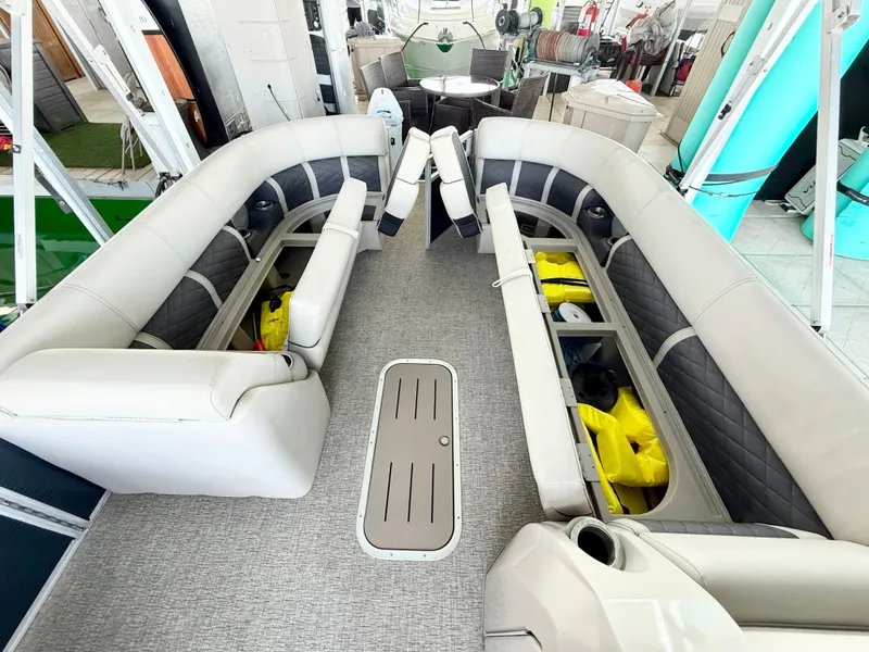 Slide: The Image of 2019 Bennington SX 25 Premium Swingback interior with spacious seating and storage compartments. - 8