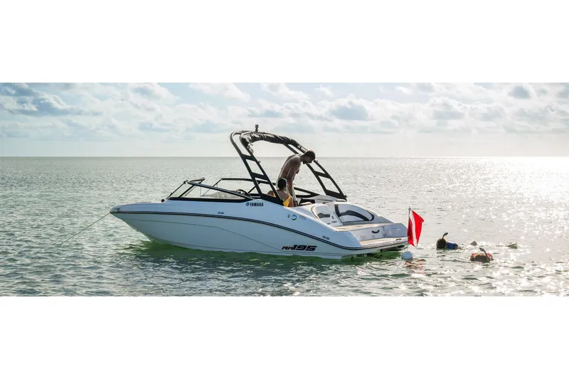 Slide: The Image of 2025 Yamaha AR195 boat on calm water with people swimming nearby. - 11