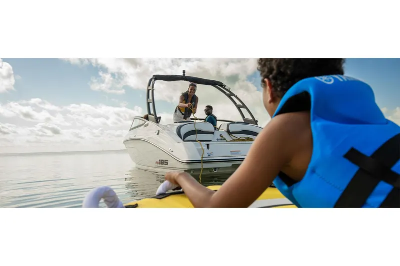 Slide: The Image of 2025 Yamaha AR195 boat on water with people enjoying a sunny day. - 9