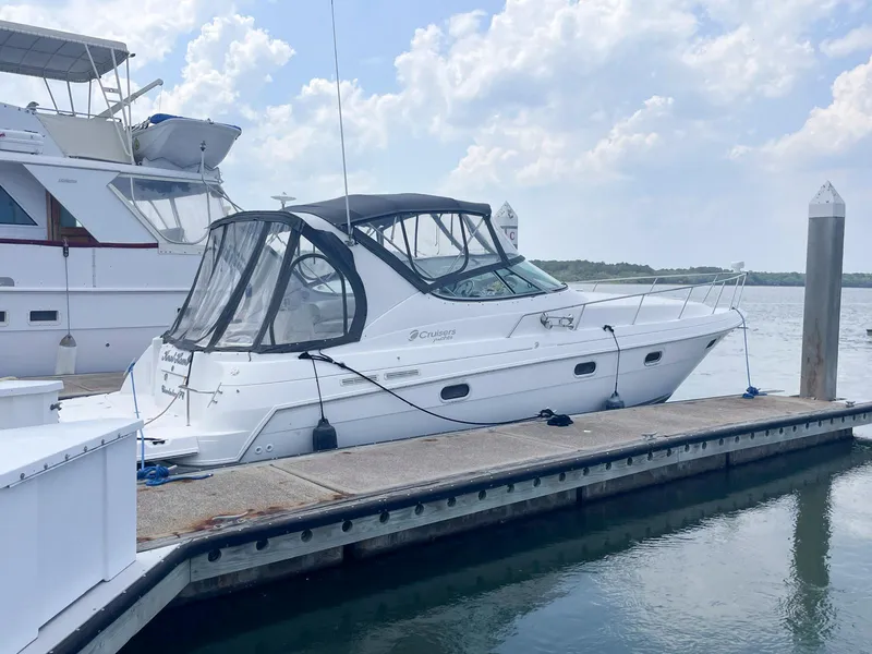 The Image of 1998 Cruisers Yachts 3375 Esprit docked at marina under cloudy sky. - 0