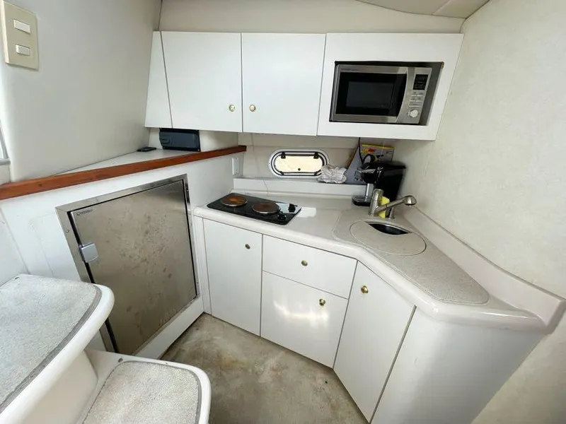 Slide: The Image of 1998 Cruisers Yachts 3375 Esprit galley with microwave, stove, and compact fridge. - 11