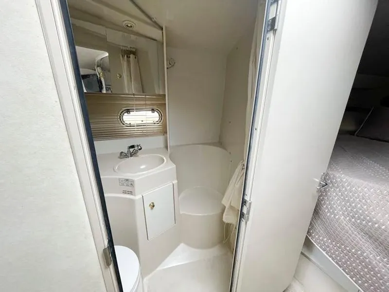 Slide: The Image of 1998 Cruisers Yachts 3375 Esprit bathroom with sink, shower, and porthole window. - 16