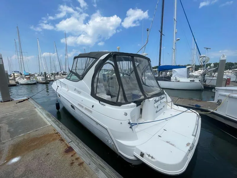 Slide: The Image of 1998 Cruisers Yachts 3375 Esprit docked at marina under blue sky. - 3