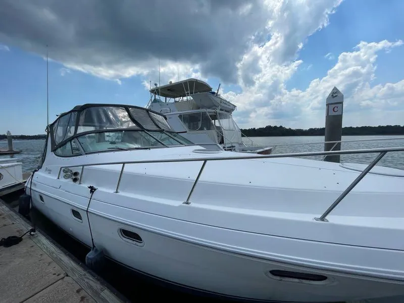 Slide: The Image of 1998 Cruisers Yachts 3375 Esprit docked by the water under a cloudy sky. - 4