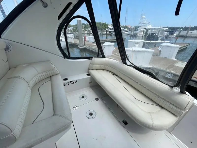 Slide: The Image of 1998 Cruisers Yachts 3375 Esprit interior with white seating, docked at marina. - 5