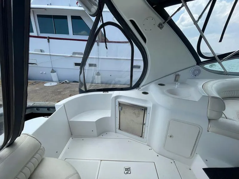 Slide: The Image of 1998 Cruisers Yachts 3375 Esprit interior with seating and storage, docked near another boat. - 6