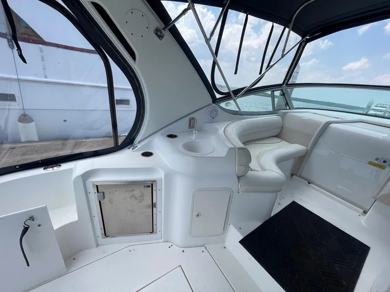 Slide: The Image of 1998 Cruisers Yachts 3375 Esprit interior with white seating and sink, docked by the water. - 7