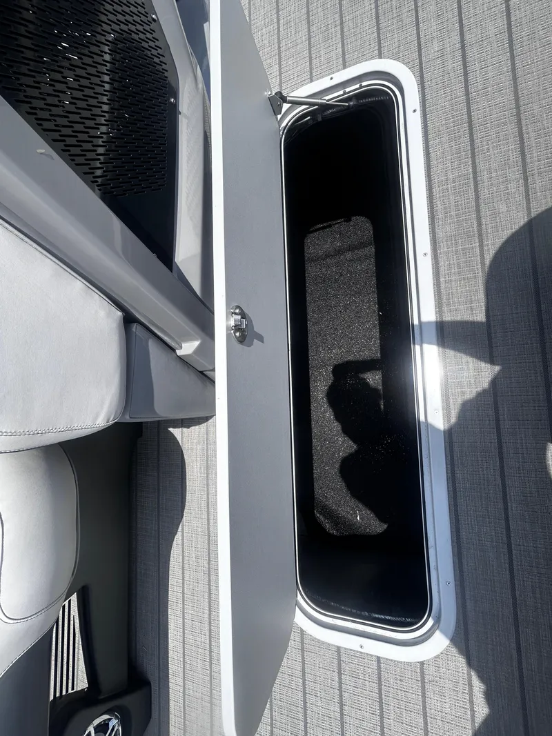 Slide: The Image of Open storage compartment on Avalon CAT VRB25T boat, 2025 model, with sleek interior design. - 17