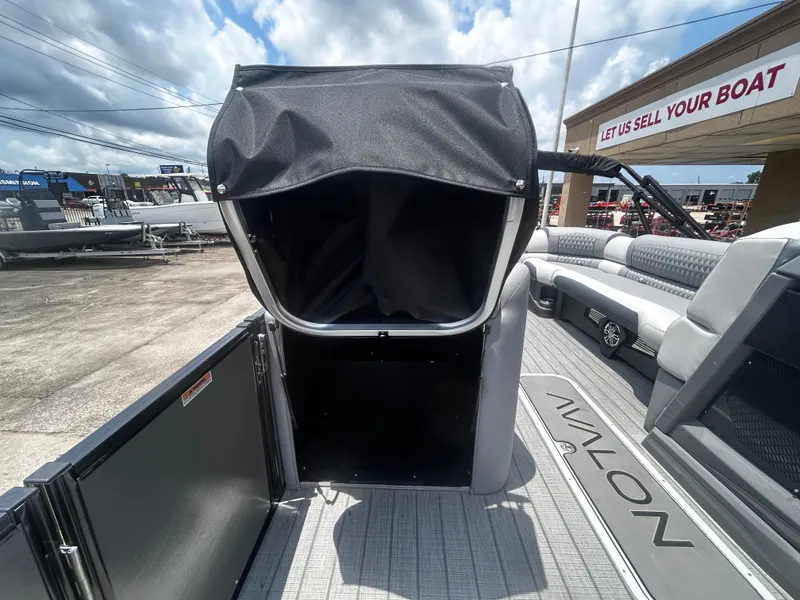 Slide: The Image of 2025 Avalon CAT VRB25T boat interior with seating and storage, dealership background. - 20