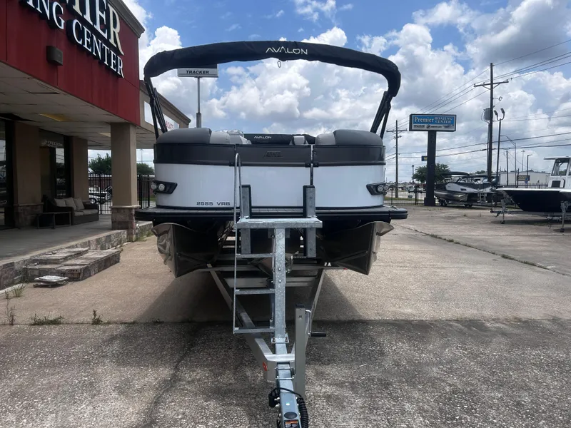 Slide: The Image of 2025 Avalon CAT VRB25T boat on trailer at dealership, under a cloudy sky. - 5