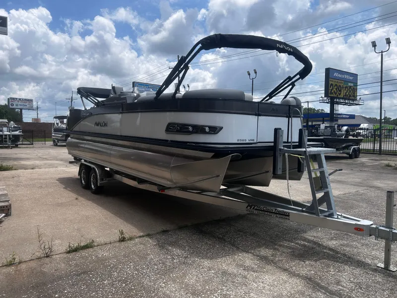 Slide: The Image of 2025 Avalon CAT VRB25T pontoon boat on trailer under cloudy sky. - 6