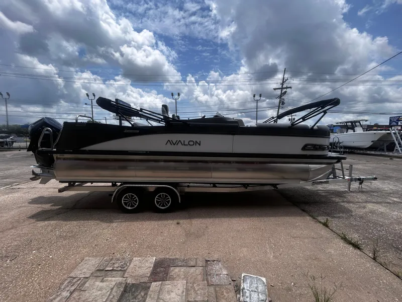 Slide: The Image of 2025 Avalon CAT VRB25T pontoon boat on trailer under cloudy sky. - 7