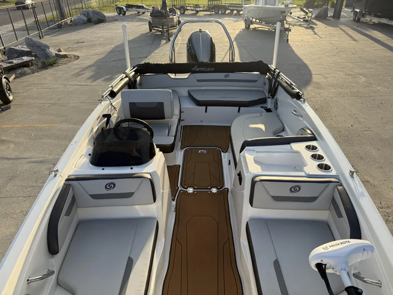 Slide: The Image of 2022 Hurricane SS205 boat interior with seating and steering console, docked outdoors. - 9