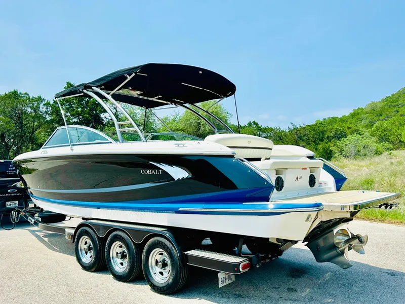 Slide: The Image of 2012 Cobalt A28 boat on trailer, black and white design, parked outdoors. - 11