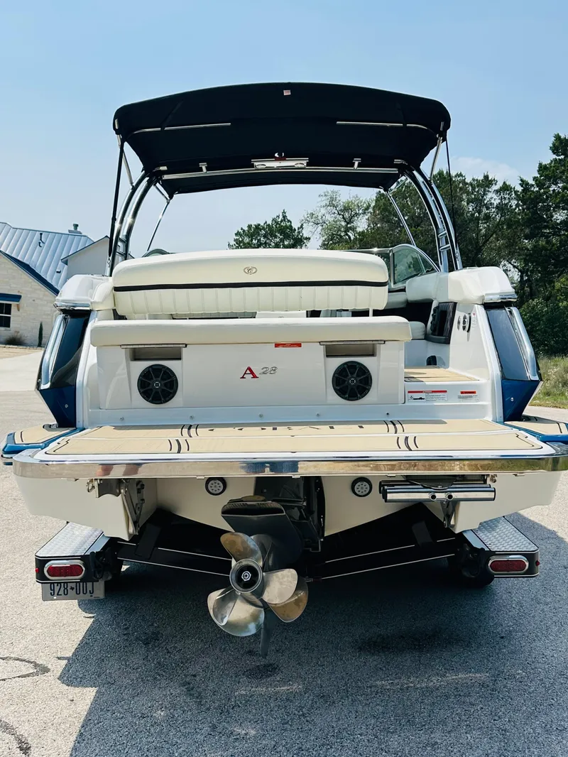 Slide: The Image of 2012 Cobalt A28 boat with swim platform and dual propellers, parked outdoors. - 12
