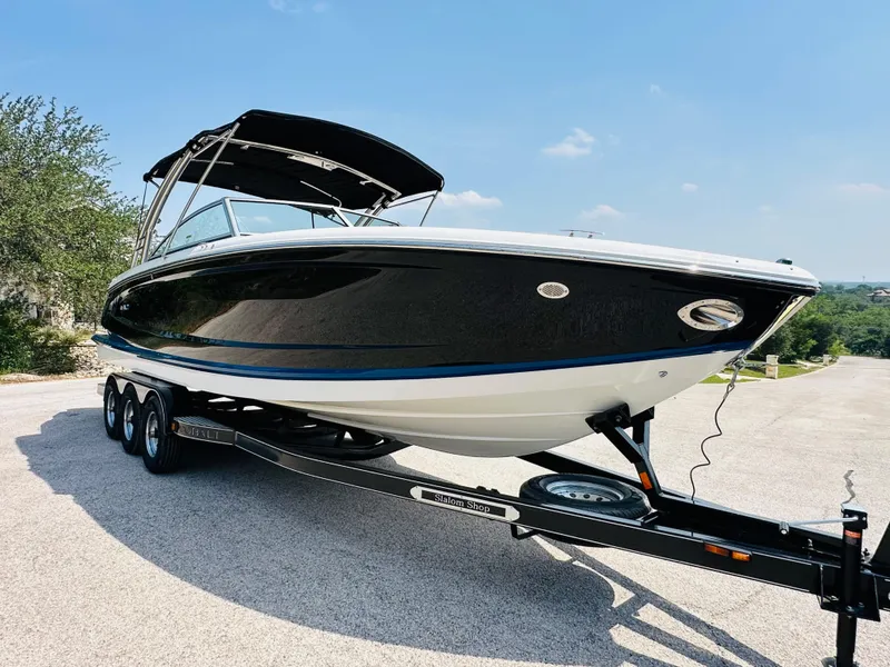 Slide: The Image of 2012 Cobalt A28 boat on trailer, black and white design, sunny day. - 15