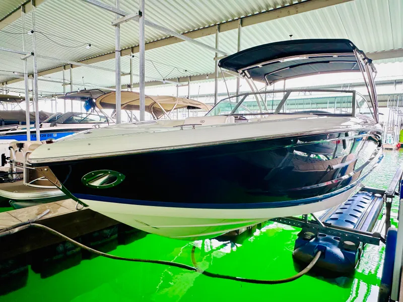 Slide: The Image of 2012 Cobalt A28 boat docked in a covered marina, featuring sleek design and blue hull. - 21