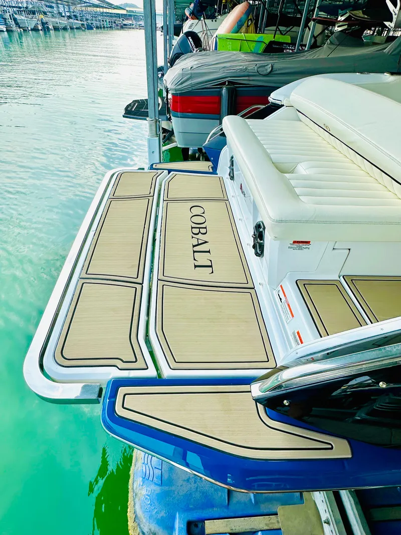 Slide: The Image of 2012 Cobalt A28 boat with teak deck, docked on calm water. - 24