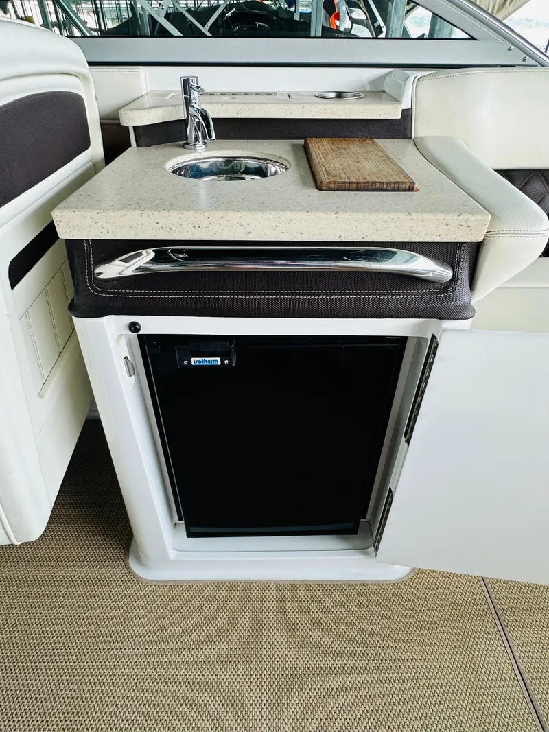 Slide: The Image of 2012 Cobalt A28 boat kitchenette with sink, cutting board, and mini fridge. - 36
