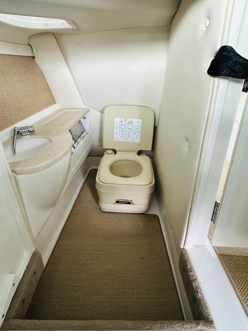 Slide: The Image of 2012 Cobalt A28 boat interior bathroom with compact toilet and sink. - 43