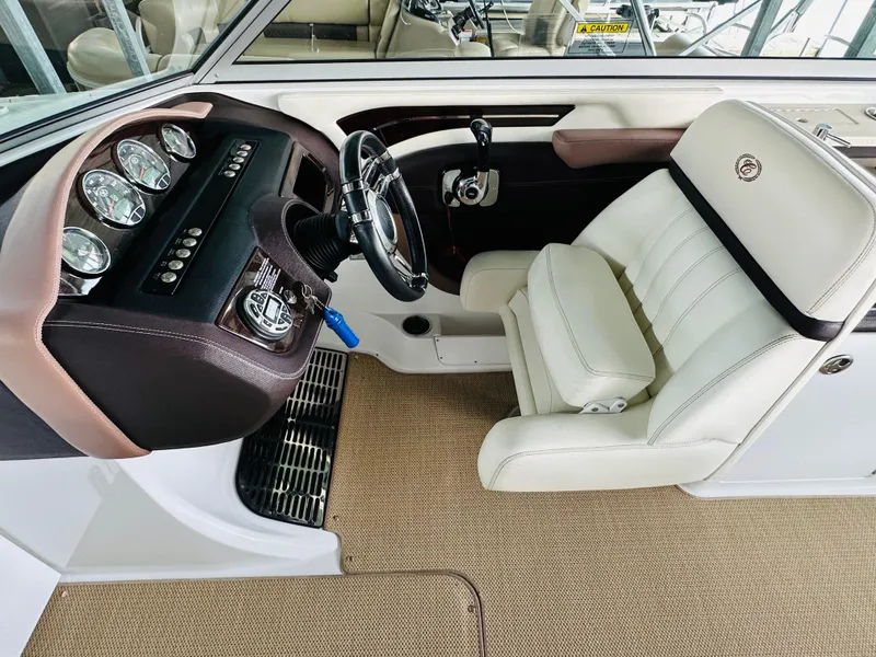 Slide: The Image of Interior of a 2012 Cobalt A28 boat with white leather seating and dashboard controls. - 46