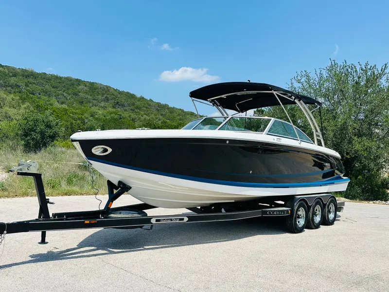 Slide: The Image of 2012 Cobalt A28 boat on trailer, parked outdoors with scenic background. - 9