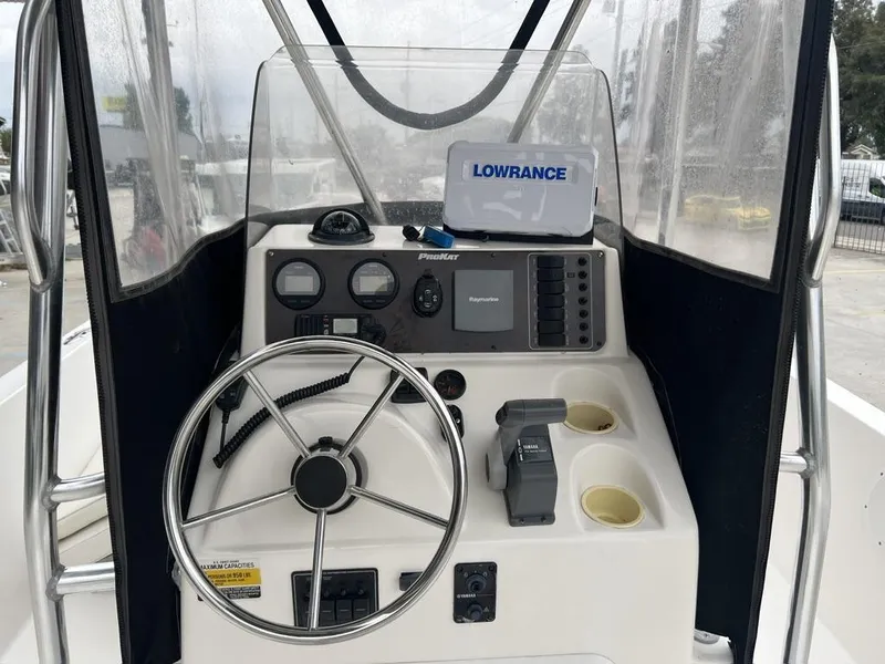 Slide: The Image of 2005 ProKat Bay Kat boat dashboard with steering wheel and navigation equipment. - 8
