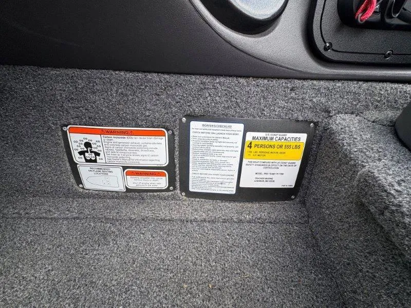 Slide: The Image of 2019 Tracker Pro Team 175 warning labels and capacity information on carpeted interior. - 43
