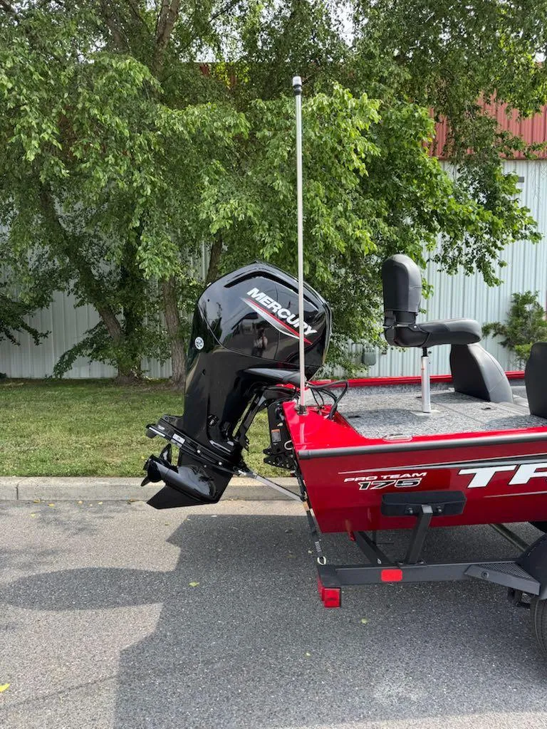 Slide: The Image of 2025 Tracker Pro Team 175 boat with Mercury outboard motor, parked outdoors. - 2