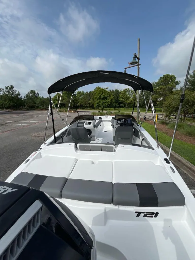 Slide: The Image of 2025 Tahoe T21 boat with canopy, parked outdoors under a cloudy sky. - 3
