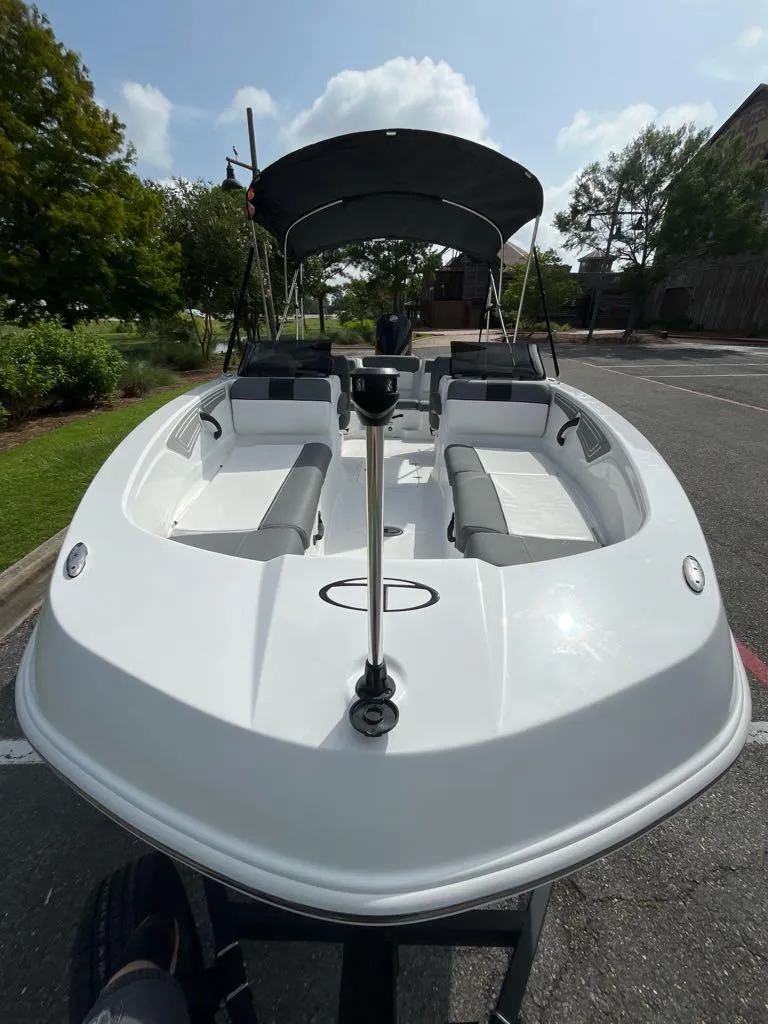 Slide: The Image of 2025 Tahoe T21 boat with canopy, parked outdoors on a sunny day. - 7