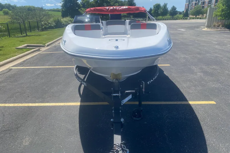 Slide: The Image of 2025 Tahoe T16 boat parked in a sunny lot, front view. - 2