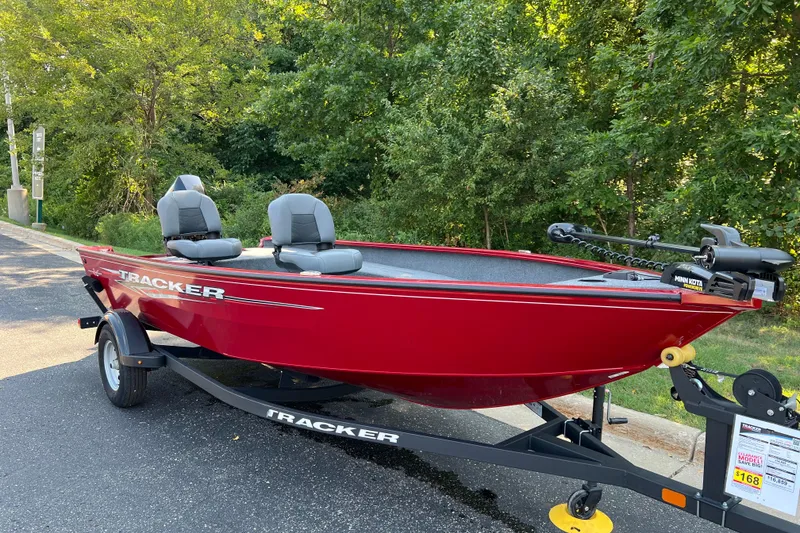 Slide: The Image of 2025 Tracker Super Guide V-16 T boat in vibrant red on a trailer, parked outdoors. - 2