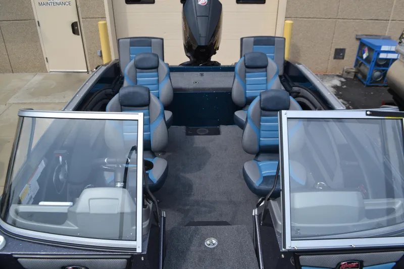 Slide: The Image of 2025 Ranger 1880MS boat interior with blue and gray seating, open windshield, and motor view. - 4