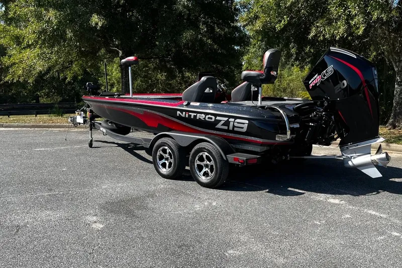 Slide: The Image of 2025 Nitro Z19 boat with trailer, parked outdoors under trees. - 3