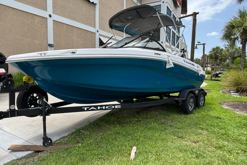 Slide: The Image of 2025 Tahoe 200 S boat on trailer, parked outdoors near a building. - 2