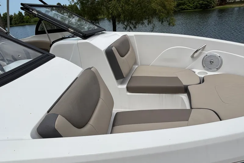 Slide: The Image of 2025 Tahoe 200 S boat interior with comfortable seating by a serene lake. - 94