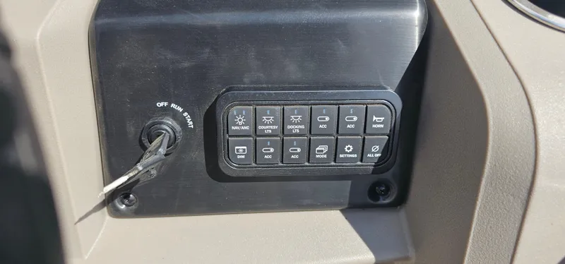 Slide: The Image of Control panel of 2025 Sun Tracker Party Barge 20 DLX with ignition key and buttons. - 13