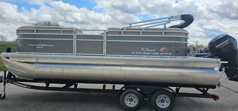 Slide: The Image of 2025 Sun Tracker Party Barge 20 DLX pontoon boat on trailer, under cloudy sky. - 3