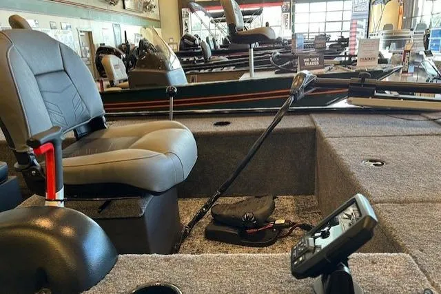 Slide: The Image of 2025 Tracker Panfish 17 boat interior with seating and control panel in showroom. - 3