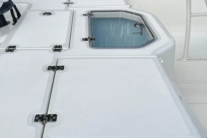 Slide: The Image of 2024 Mako Pro Skiff 19 CC deck with storage compartments and livewell. - 10